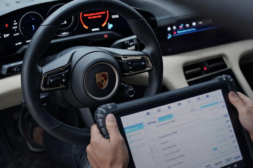 車內以平板進行系統診斷與車況檢視,方向盤與數位儀表顯示專業檢測情境